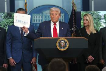 El presidente de EE.UU., Donald Trump (C), sostiene un documento mientras se dirige a los medios en la sala de prensa James S. Brady de la Casa Blanca, en Washington.