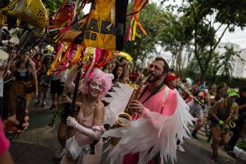 Personas participan en el desfile de la comparsa callejera Fanfarra Manada este sábado, en Sao Paulo (Brasil). Desde el amanecer, cientos de miles de personas se tomaron las calles de las principales ciudades de Brasil para celebrar el Carnaval, la fiesta más grande del país, en coloridas y ruidosas comparsas. EFE/ Isaac Fontana