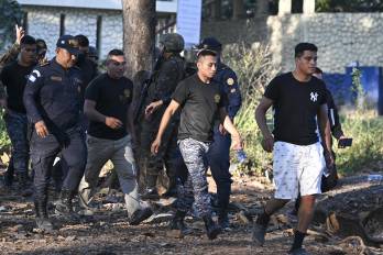 Guardias del Sistema Penitenciario caminan tras ser rescatados tras un motín en las afueras del penal de máxima seguridad Renovación I en Escuintla, Guatemala, el 18 de enero de 2026.