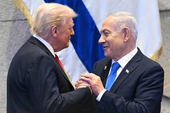 El presidente estadounidense Donald Trump (izq.) toma de la mano y conversa con el primer ministro israelí Benjamin Netanyahu en el Parlamento israelí.