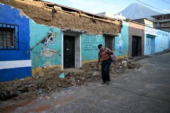 Un hombre camina junto a la pared derrumbada de una tienda después de que una serie de terremotos sacudieran el área en Palin, Guatemala, el 9 de julio de 2025.