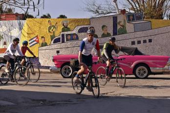 Turistas hacen un recorrido en bicicletas junto a un mural del artista plástico Fuster en Jaimanitas este martes, en La Habana (Cuba).