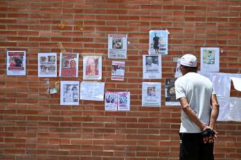 Un hombre observa fotografías de personas desaparecidas en Caraballeda, estado de La Guaira, Venezuela, el 1 de julio de 2026, tras los dos terremotos del 24 de junio.