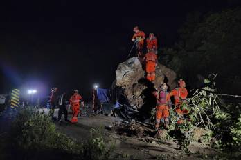 Esta fotografía, distribuida por los Bomberos Voluntarios de Guatemala, muestra a bomberos voluntarios trabajando para recuperar los cuerpos de dos personas que fallecieron después de que su vehículo quedara sepultado bajo rocas