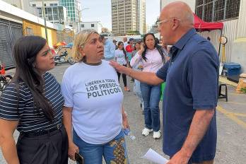 Presidente de la Asamblea Nacional de Venezuela, Jorge Rodríguez (d), hablando con familiares de presos políticos frente al Centro de detención Zona 7.