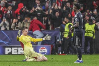 El jugador del Real Madrid, Vinícius Jr. (der.) y el portero del Benfica, Anatoliy Trubin.