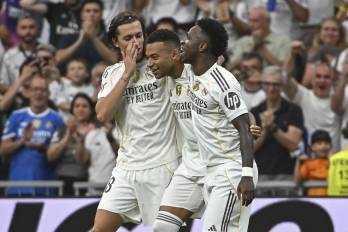 El delantero francés del Real Madrid Kylian Mbappé (c) celebra con Álvaro Carreras (izda) y Vinicius el segundo gol conseguido durante el partido de la jornada 5 de LaLiga EA Sports, que disputan el Real Madrid y el RCD Espanyol, en el estadio Santiago Bernabéu de la capital española. EFE/Fernando Villar