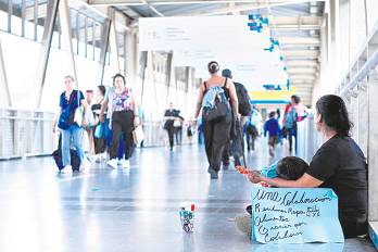 Madre venezolana vendiendo golosinas con su hijo pequeño.