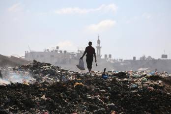 Un palestino busca objetos para rescatar en un vertedero de basura en el campamento de Al-Bureij, en el centro de la Franja de Gaza, el 7 de julio de 2025.