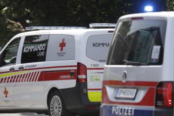 Una ambulancia y un carro de la policía afuera de un colegio en Austria en el que ocurrió un ataque a tiros.