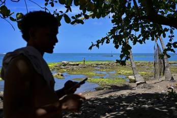 Migrantes venezolanos permanecen en la playa mientras esperan un bote que los lleve a Colombia en Miramar, cerca de Palenque.