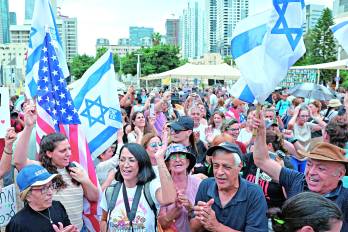 Personas en las calles de Tel Aviv con banderas de los Estados Unidos.