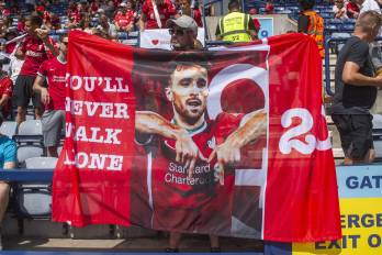 Fanáticos del Liverpool portan carteles en memoria de Diogo Jota en el primer partido del Liverpool.