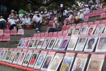 Fotografías de personas desaparecidas expuestas en el malecón para conmemorar el Día Internacional de las Víctimas de Desaparición Forzada este domingo en Cúcuta (Colombia).