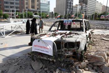 Iraníes revisan una ambulancia de la Media Luna Roja Iraní destruida durante un ataque israelí, exhibida ayer en Teherán.