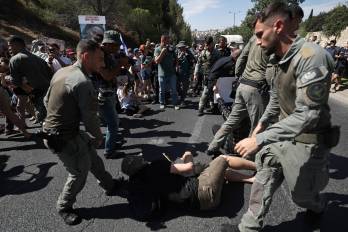 Agentes de policía israelíes intentan retirar a los manifestantes que bloquearon una carretera principal en Jerusalén.