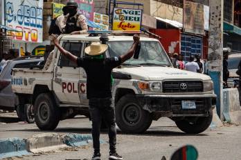 Se ve a un hombre que levanta los brazos frente a unos agentes policiales durante una protesta contra la inseguridad y la violencia en Puerto Príncipe (Haití).