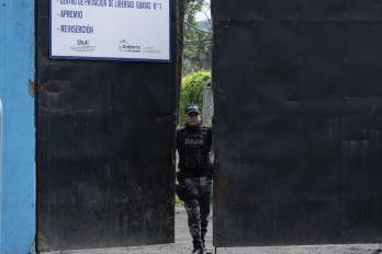 Miembro de la Policía Nacional Ecuatoriana cerrando la puerta del complejo penitenciaro Del Litoral.