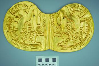Pectoral de oro martillado en forma de mariposa, repujado con imágenes de dos ciervos y cocodrilo.