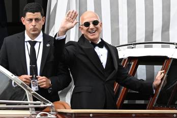 El fundador de Amazon, Jeff Bezos (der.), saluda a la multitud al salir de su hotel en Venecia, Italia, el 27 de junio de 2025, en el segundo día de la celebración de su boda.
