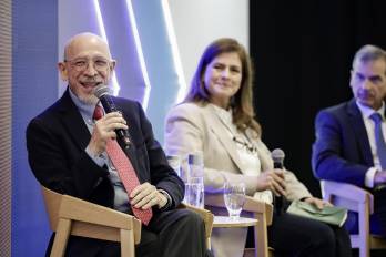 El doctor Francisco Becerra (i) consultor en salud pública y políticas sanitarias, participa durante un foro organizado por la compañía Roche, este martes en San José.