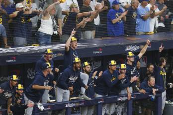 Jugadores de los Cerveceros celebran las carreras de su equipo en el quinto inning del tercer juego de la Serie Mundial de béisbol ante los Rays.