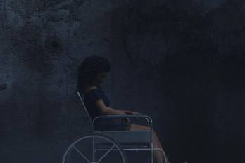 La silla de ruedas y la figura fantasmal de Alma simbolizan el deterioro emocional y la culpa del protagonista.