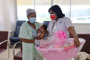 Madre recibe una canastilla para su bebé en el Hospital Santo Tomás.