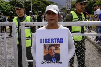 Una mujer colombiana sostiene una foto de un familiar detenido en Venezuela durante una protesta en el Puente Internacional Simón Bolívar.