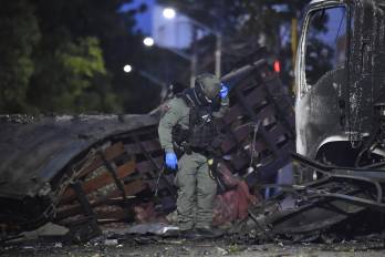 Miembros de la fuerza pública inspeccionan la zona donde explotó un camión bomba cerca de una estación policial en Cúcuta.