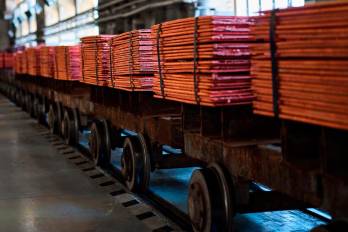Pilas de hojas de cobre en vagones de un ferrocarril en una planta de refinería metálica.