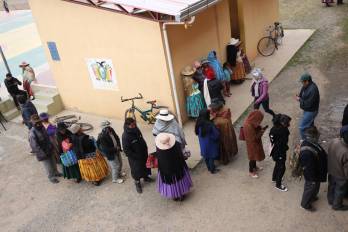 Personas esperan en una fila este domingo, para votar en la segunda vuelta electoral en la comunidad de Laja (Bolivia).