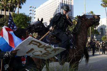 Oficiales del Departamento de Policía de Los Ángeles se enfrentan este miércoles con manifestantes frente al Ayuntamiento de Los Ángeles (EE.UU.). EFE/EPA/CAROLINE BREHMAN