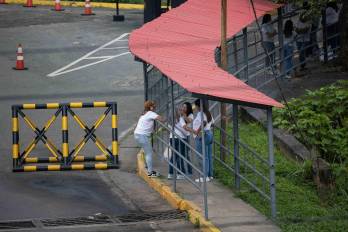 Personas hablan en la entrada del centro penitenciario Rodeo I este sábado, en Zamora estado de Miranda (Venezuela).