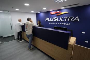 Personas verifican boletos en las oficinas de la aerolínea Plus Ultra en Caracas (Venezuela).