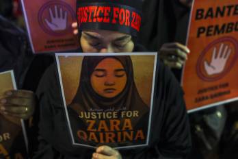 Una ciudadana malasia muestra en una manifestación una fotografía de Zara Qairina, una niña de 13 años que fue encontrada muerta cerca de su escuela en Sabah.