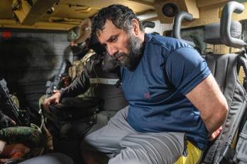 El narcotraficante José Adolfo Macías Villamar 'Fito' (d), es custodiado este miércoles, en Guayaquil (Ecuador). ´Fito' llegó a la Base aérea de Guayaquil, tras ser capturado en la ciudad de Manta, para ser recluido en la cárcel de máxima seguridad La Roca.