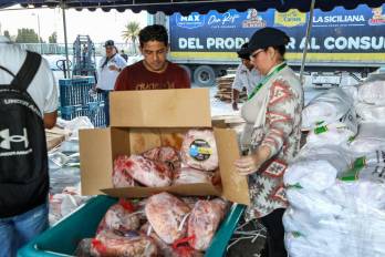 Trabajadores del IMA en una de las últimas ferias que realizó la entidad para vender jamones navideño.
