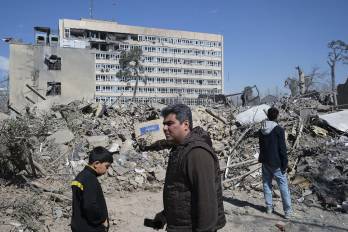 Varias personas caminan cerca de una zona alcanzada por los bombardeos israelíes-estadounidenses en los alrededores del Gran bazar de Teherán.