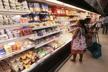 Una señora observa atentamente la lista de productos lácteos que se ofrecen en un supermecado de la ciudad de Panamá.