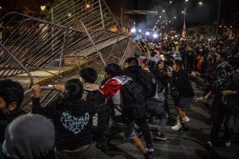 Personas tumban una valla durante una manifestación en Lima (Perú), en una fotografía de archivo.