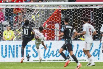 Jonathan David (i) de Canadá anota su segundo gol del partido ante la marca del defensor catarí Boualem Khoukhi (c) durante el encuentro de la fase de grupos de la Copa Mundial de la FIFA 2026 entre Canadá y Catar, disputado en Vancouver.