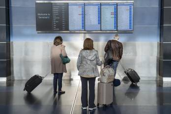 Varios pasajeros observan los monitores del aeropuerto John F. Kennedy este viernes, en la ciudad de Nueva York.