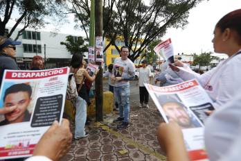 Integrantes de colectivos de búsqueda pegan carteles de personas desaparecidas este sábado, en Guadalajara (México). EFE/Francisco Guasco