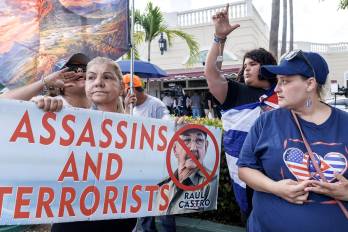Cubanos en el exilio sostienen un cartel que dice Asesinos y terroristas mientras celebran el Día de la República de Cuba en Miami, Florida, EE. UU., el 20 de mayo de 2026. EFE/RISTOBAL HERRERA-ULASHKEVICH