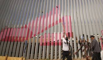 Artistas pintan con colores el nuevo muro instalado en la frontera con Estados Unidos.