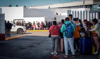 Migrantes hacen fila para solicitar un proceso de asilo en Estados Unidos, el 22 de febrero de 2024 en el paso fronterizo del Chaparral, en Baja California (México).