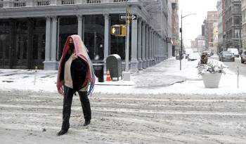 Una persona camina por una calle de Nueva York cubierta por la nieve, en una fotografía de archivo.