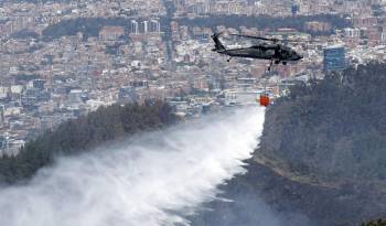 Un helicóptero de la Fuerza Aérea Colombiana (FAC) participa en labores de extinción de los incendios en los cerros orientales de Bogotá.