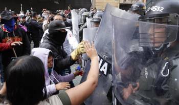 Personas se enfrentan con la Policía durante una protesta hoy en Bogotá.